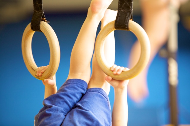 Child upside down on the rings